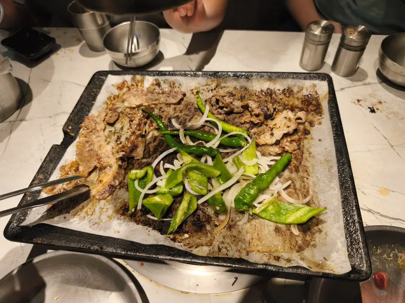 Grilling meat, green peppers and onions